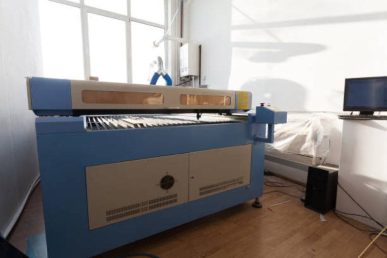 Machine de découpe et gravure laser CO2 grand format à capot fermé, installée dans un atelier